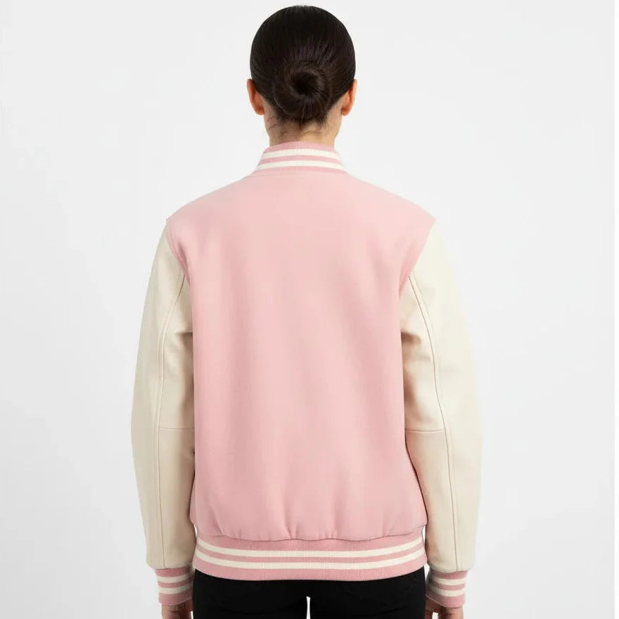 Person wearing a pink and beige varsity jacket on a white background