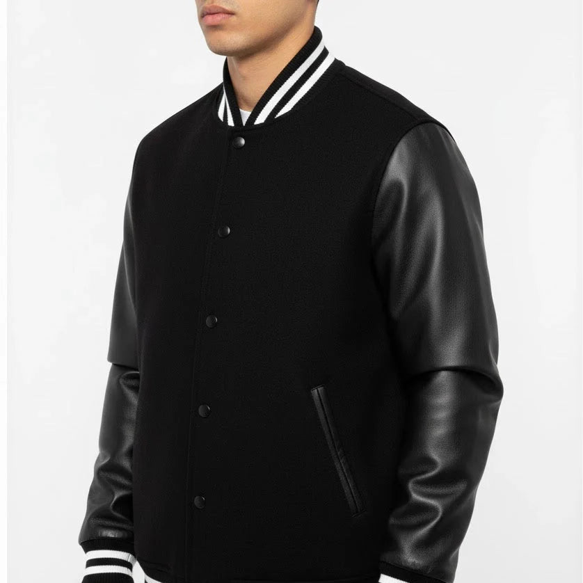 Black varsity jacket with leather sleeves on a white background