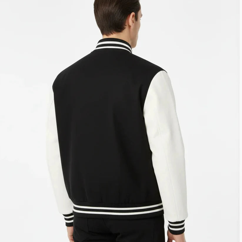 Person wearing a black and white varsity jacket on a white background